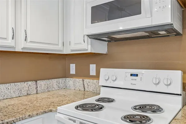 a bathroom with a granite countertop sink a toilet and a mirror