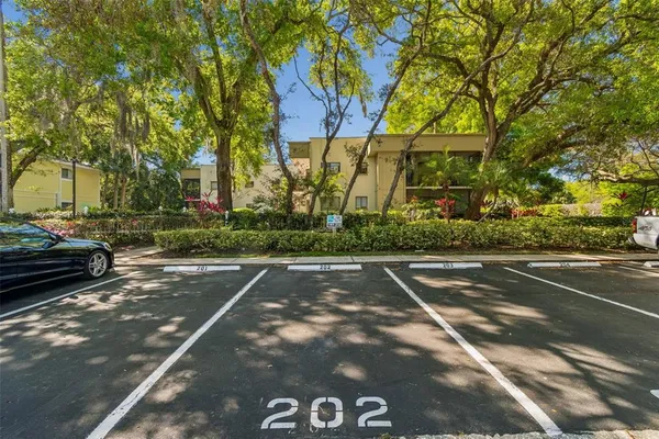 a front view of a house with a yard and fountain in middle