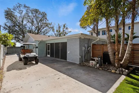 a front view of a house with glass windows and plants