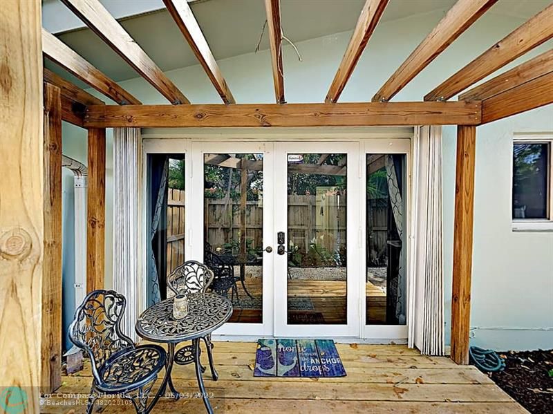 a view of a patio with table and chairs and floor to ceiling window