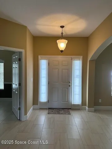 an empty room with wooden floor and mirror