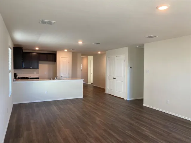 a view of kitchen with kitchen island wooden floor center island and stainless steel appliances