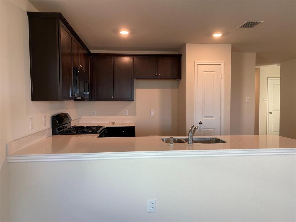 4408 Culrin Way Forney, TX 75126 - Photo 9 of 17 a kitchen with granite countertop a sink and a stove top oven