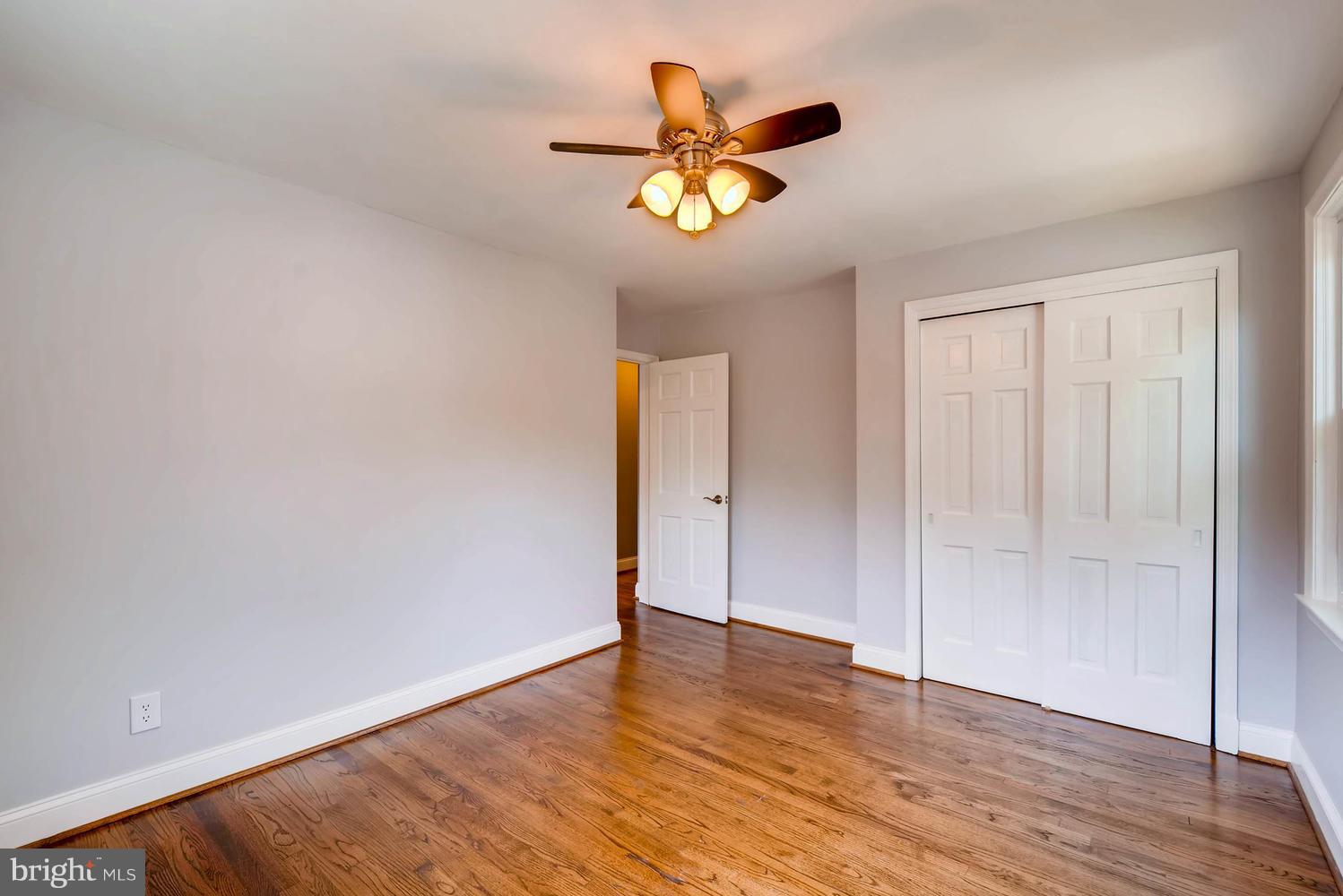 4823 Briarclift Road Baltimore, MD 21229 - Photo 22 of 30 a view of an empty room with wooden floor and a ceiling fan