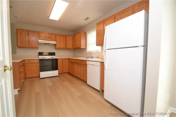 a kitchen with a sink cabinets stainless steel appliances and window