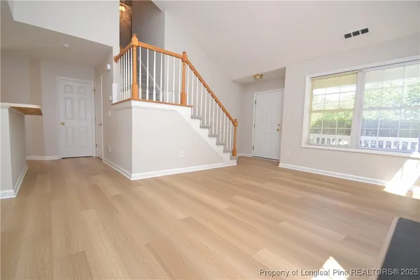 a view of empty room with wooden floor and fireplace