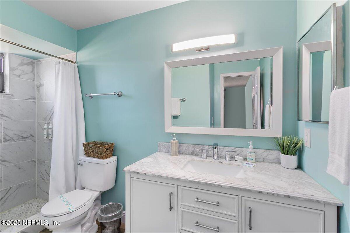 898 Perkins Place Jacksonville, FL 32221 - Photo 13 of 21 a bathroom with a granite countertop sink toilet mirror and shower