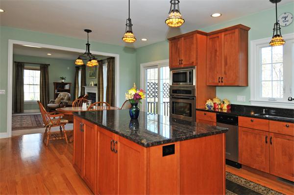 18 Wilkes Road Rowley, MA 01969 - Photo 5 of 29 a kitchen with stainless steel appliances granite countertop a stove top oven a refrigerator a dining table and chairs with wooden floor