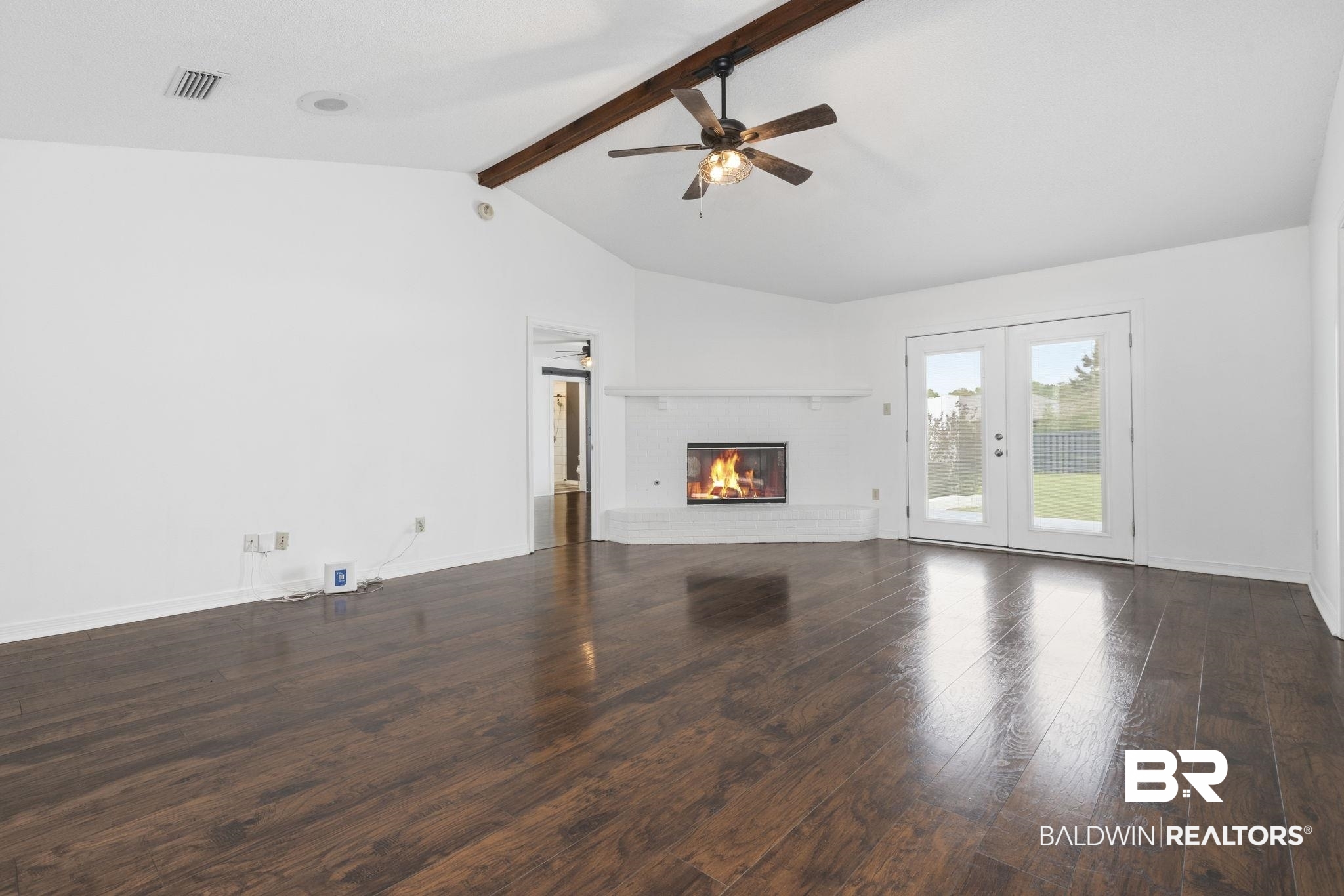 10670 Jeff Hamilton Road Mobile, AL 36695 - Photo 21 of 43 Unfurnished living room with dark wood-type flooring, a fireplace, a ceiling fan, and french doors