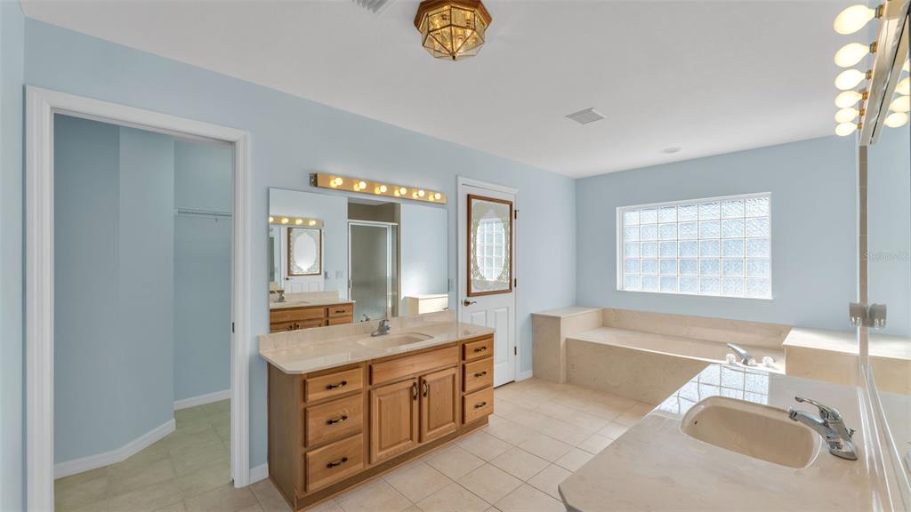 4647 Northeast 15th Street Ocala, FL 34470 - Photo 11 of 45 a bathroom with a granite countertop double vanity sink a mirror and a bathtub