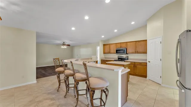 a kitchen with stainless steel appliances kitchen island granite countertop a refrigerator and a stove top oven