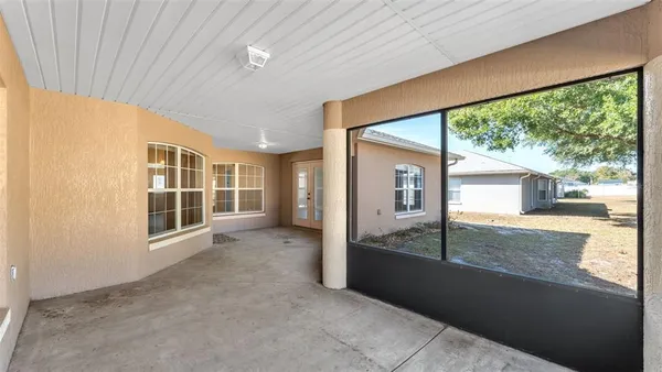 an empty room with large windows and a table