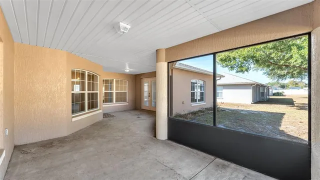 an empty room with large windows and a table