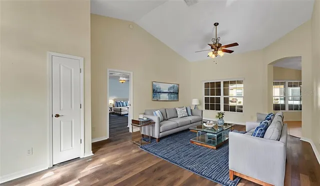 a living room with furniture a ceiling fan and a window