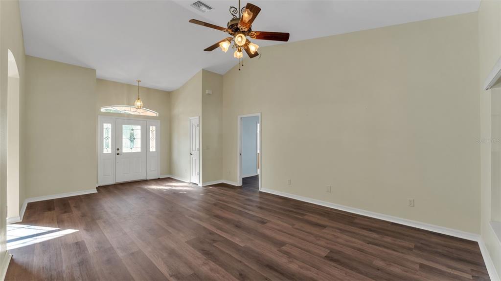 4647 Northeast 15th Street Ocala, FL 34470 - Photo 5 of 45 a view of an empty room with a window and wooden floor