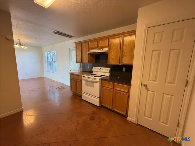 a kitchen with granite countertop a sink cabinets and stainless steel appliances