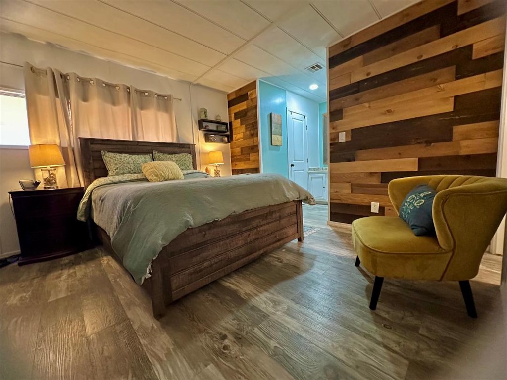 1395 Lause Road Bullhead City, AZ 86442 - Photo 16 of 34 Distinguished main bedroom featuring a striking wood plank accent wall and wood-finish flooring
