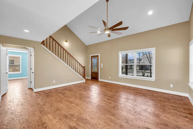 a view of a big room with wooden floor and a ceiling fan