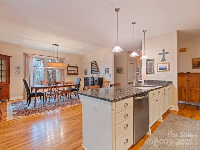 a kitchen with stainless steel appliances granite countertop a stove a sink and a wooden floors