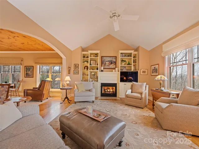 a living room with furniture fireplace and a large window