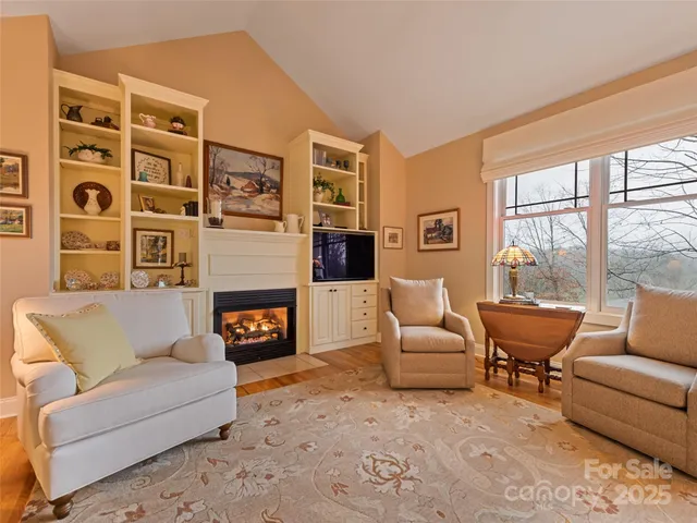 a living room with furniture large window and fireplace