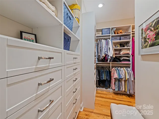 a view of walk in closet with clothes and shoes