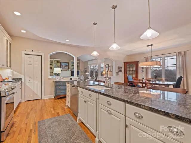 a large kitchen with kitchen island a large counter space a sink appliances and living room view