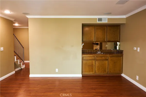 a view of an empty room with wooden floor