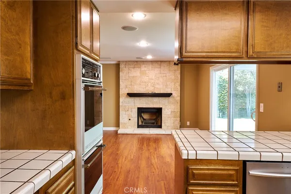 a room with kitchen island wooden floors and wooden cabinets