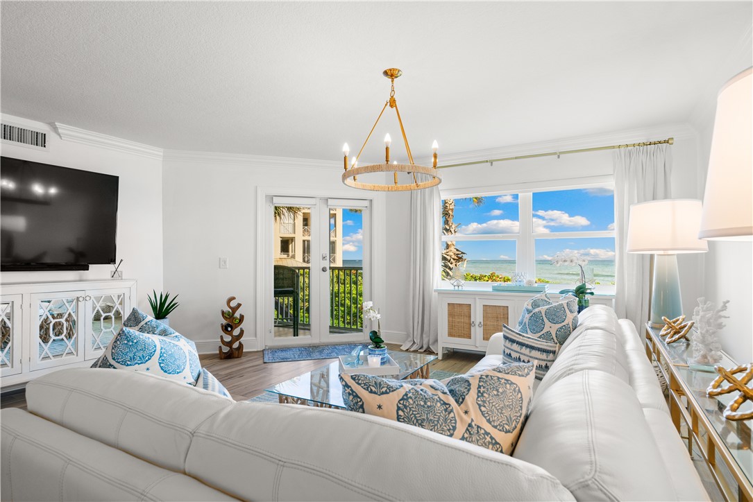 8880 North Sea Oaks Way, Unit 103 Vero Beach, FL 32963 - Photo 1 of 36 a living room with furniture a flat screen tv and a large window