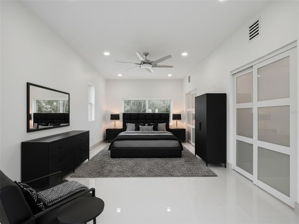 28055 Leuty Road Yalaha, FL 34797 - Photo 23 of 39 a living room with furniture a flat screen tv and a fireplace