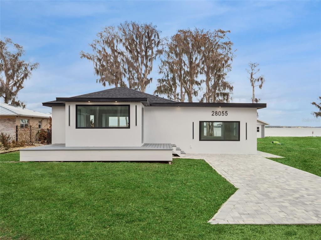 28055 Leuty Road Yalaha, FL 34797 - Photo 3 of 39 a front view of a house with a garden and yard