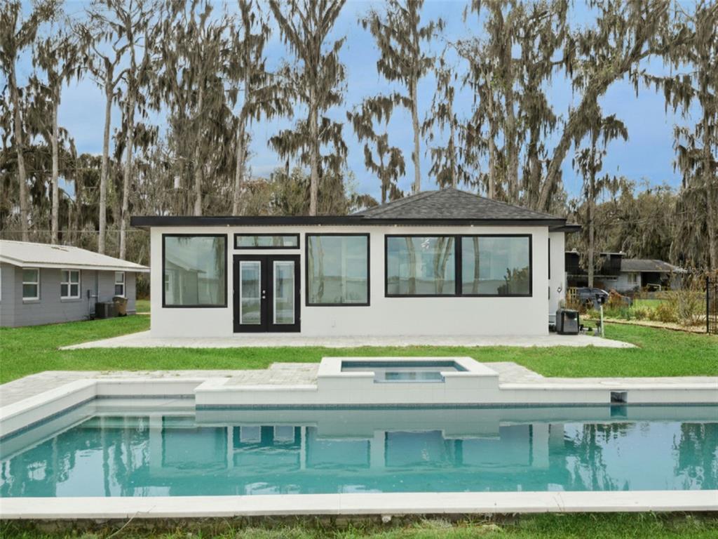 28055 Leuty Road Yalaha, FL 34797 - Photo 37 of 39 a view of a white house next to a yard with big trees