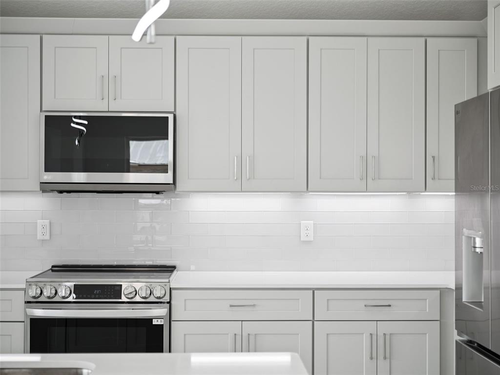 28055 Leuty Road Yalaha, FL 34797 - Photo 8 of 39 a kitchen with granite countertop white cabinets and stainless steel appliances