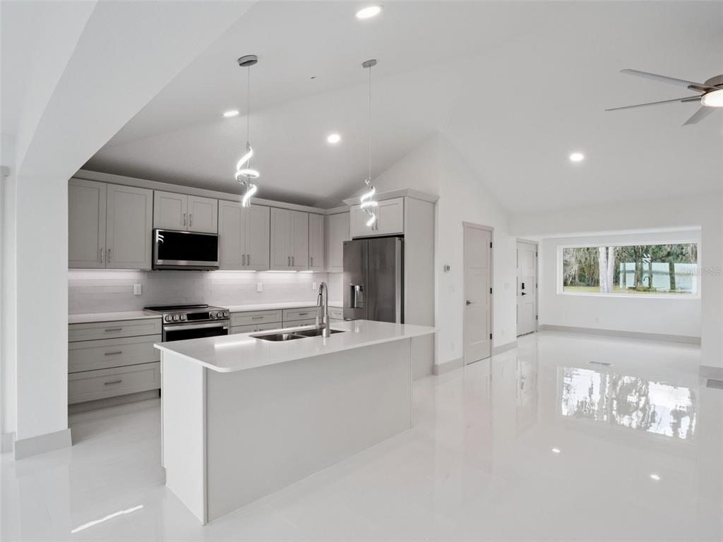 28055 Leuty Road Yalaha, FL 34797 - Photo 9 of 39 a kitchen with stainless steel appliances granite countertop a stove a sink and a refrigerator