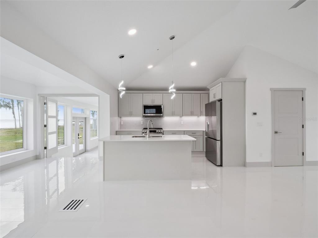 28055 Leuty Road Yalaha, FL 34797 - Photo 10 of 39 a large white kitchen with a large window and stainless steel appliances