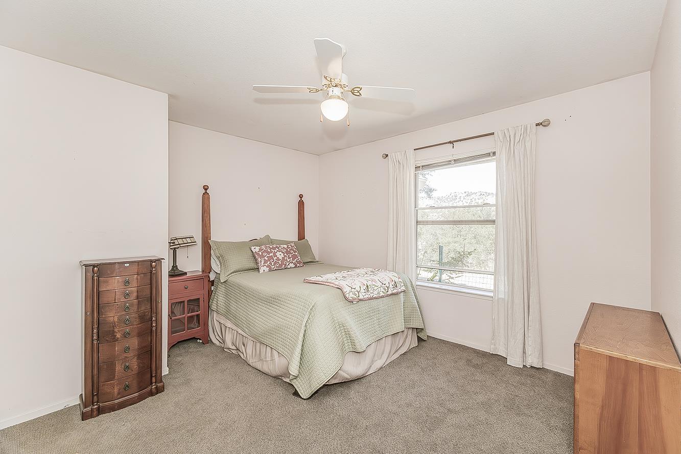 14815 Garlock Lane Prather, CA 93651 - Photo 25 of 80 a spacious bedroom with a bed and a chandelier