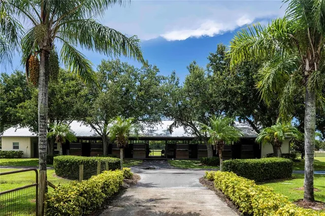 a front view of a house with a yard and potted plants