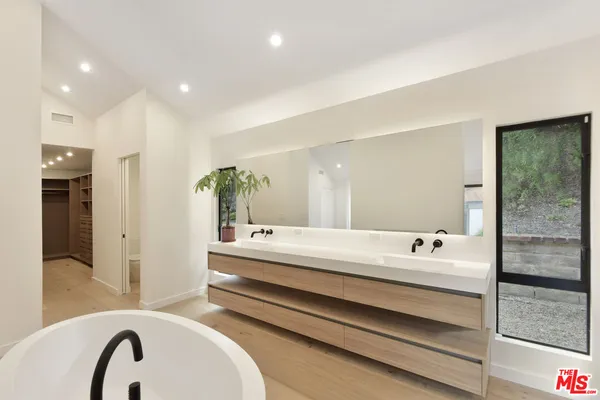 a bathroom with a tub sink and mirror