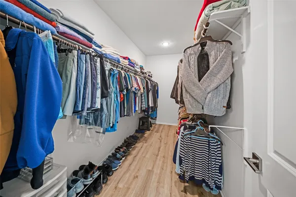 a view of walk in closet with clothes and shoes