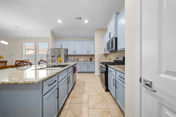 a large kitchen with granite countertop a sink and a stove