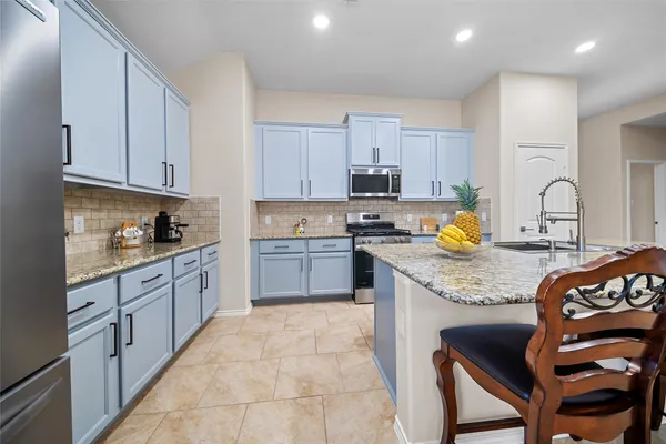 a kitchen with a stove a sink and a refrigerator