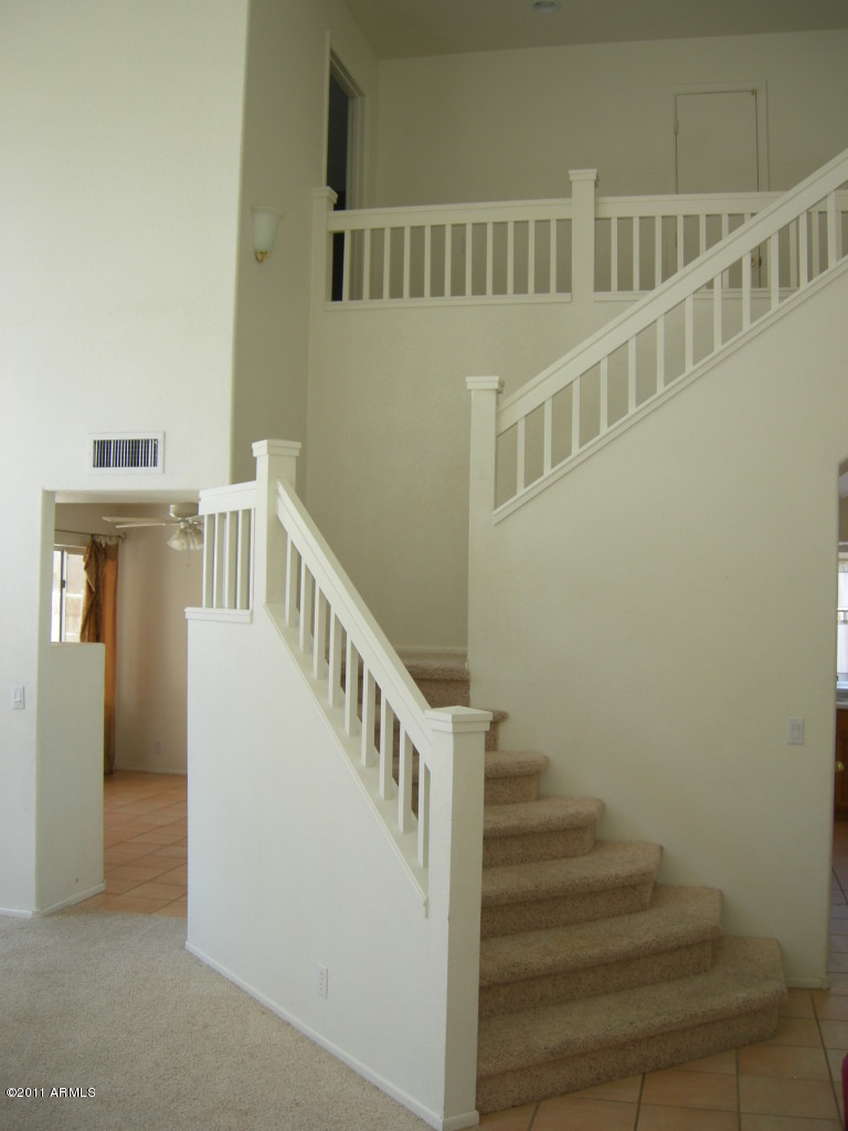 3213 East Marco Polo Road Phoenix, AZ 85050 - Photo 13 of 30 a view of staircase with lots of frames on wall and a window