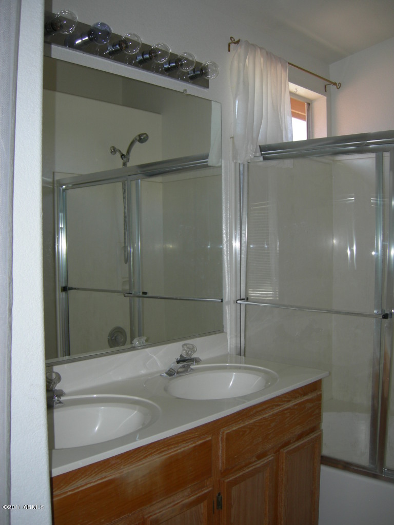 3213 East Marco Polo Road Phoenix, AZ 85050 - Photo 22 of 30 a bathroom with a granite countertop sink mirror and shower