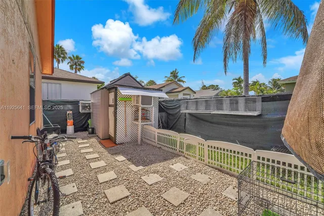 a view of a house with a small yard and potted plants