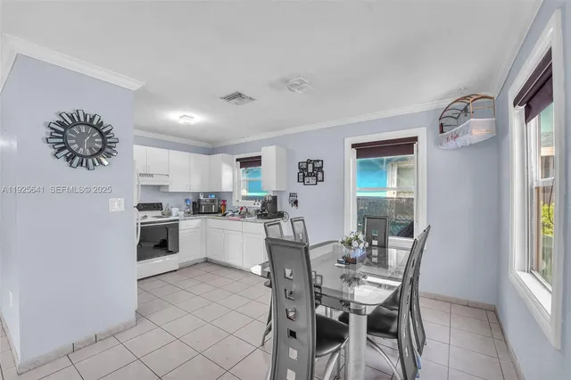 a kitchen with a dining table chairs and white cabinets