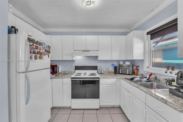 a kitchen with white cabinets and white appliances