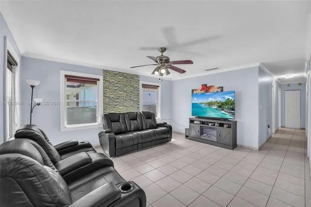 a living room with furniture a flat screen tv and a window