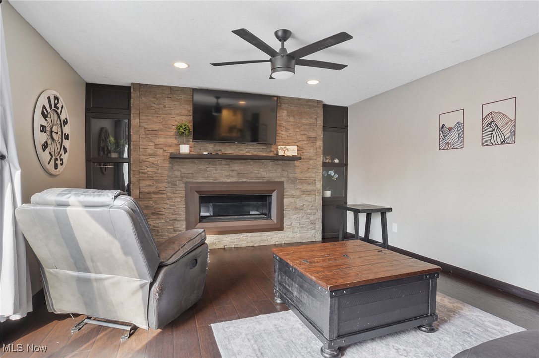 15575 Stillwell Road Huntsburg, OH 44046 - Photo 18 of 48 Family room with a ceiling fan, dark wood-style flooring, a stone fireplace, and recessed lighting