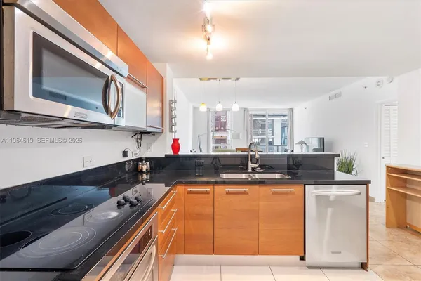 a kitchen with kitchen island granite countertop a stove and a microwave